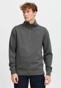 Gray, zippered sweatshirt with a high collar. Features long sleeves, ribbed cuffs, and a smooth texture. No visible patterns.