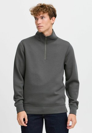 Gray, zippered sweatshirt with a high collar. Features long sleeves, ribbed cuffs, and a smooth texture. No visible patterns.