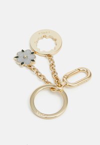 Gold keychain featuring a floral charm in silver and green, with a circle and carabiner link, and a smooth, polished texture.