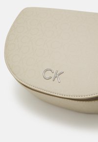 Calvin Klein DAILY SADDLE BAG MONO - Borsa a tracolla - stoney beige