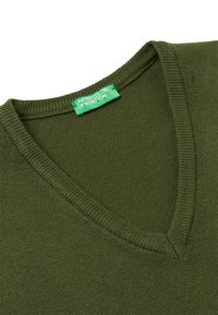 Oliwkowy sweter z dekoltem w serek, z prążkowanym kołnierzem i dolnym wykończeniem. Wykonany z miękkiego materiału, posiada metkę z napisem "United Colors of Benetton."