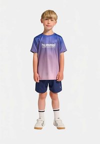 Kortärmad gradient-t-shirt i blått till rosa med "hummel PERFORMANCE"-logga, kombinerad med marinblå shorts, vita strumpor och vita sneakers.