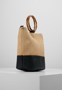 Borsa a tracolla in paglia intrecciata e pelle nera con manico rotondo in bambù, forma a secchiello e finitura testurizzata. Presenta dettagli in metallo argentato sulla tracolla.