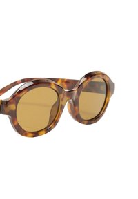 Okrągłe okulary przeciwsłoneczne z oprawką w kolorze żółwia i brązowymi soczewkami, charakteryzujące się grubymi, zaokrąglonymi krawędziami oraz bezszwowym designem.