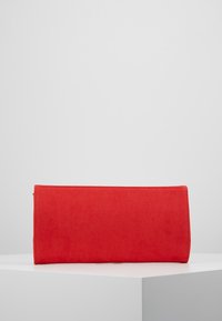 Červené semišové psaníčko obdélníkového tvaru se šitými okraji. Minimalistický design, hladká textura a bez viditelného kovového hardwaru či ozdob.