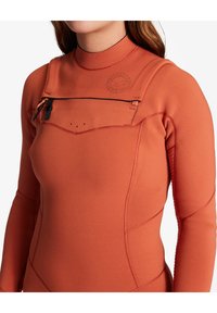 Orange våddragt med lange ærmer, frontlomme med lynlås, glat tekstur og syning detaljer; har logo på brystområdet.