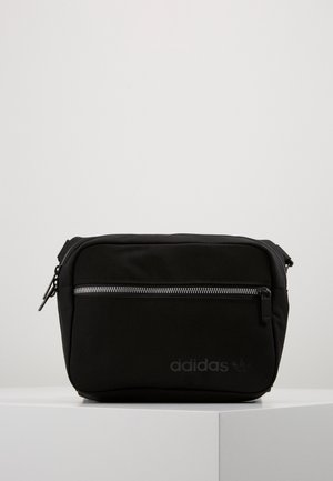Sac bandoulière noir Adidas avec poche zippée à l'avant et logo discret embossé dans le coin inférieur droit.