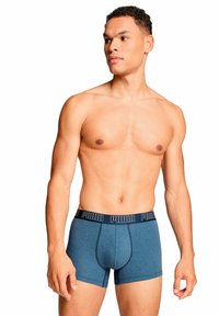 Pantaloni boxer in cotone blu con cinturino nero con logo "PUMA". Design a taglio dritto, texture liscia e dettagli di cucitura minimi.