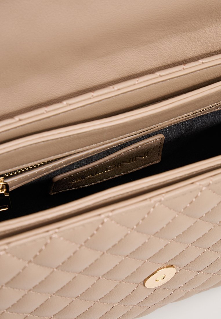 Beige gesteppte Handtasche mit glatter Textur, ausgestattet mit einem goldenen Druckverschluss und einem Reißverschlussfach. Innenfutter aus schwarzem Stoff.