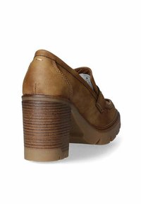 Zapato de tacón de cuero marrón con punta redondeada, tacón de madera texturizada y un diseño suave y aerodinámico; cuenta con costuras a lo largo de los bordes.