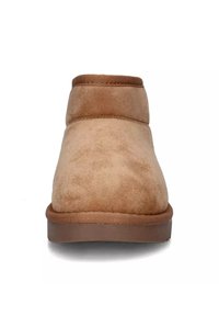 Stivale alla caviglia in suede color tan con una finitura liscia, punta rotonda e suola in gomma. Presenta un colletto imbottito e semplici dettagli cuciti.