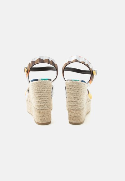 Paire de sandales compensées avec talons en corde tressée et brides de cheville multicolores à motifs géométriques avec boucles dorées, vues de dos.