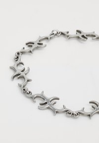 Silver bracelet with interconnected tribal-style links displayed on a white background.