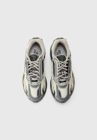 Sapatilhas cinza claro e pretas com um material texturizado. Apresentam uma biqueira arredondada, fecho de atacadores e uma palmilha com padrão. Sola em borracha.