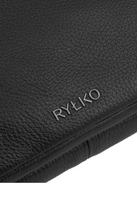 Bolso de cuero negro con una superficie texturizada; presenta un logo plateado en relieve "RYŁKO" en la parte frontal, diseño minimalista y bordes suaves.