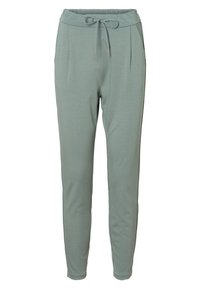 Ljust gröna, åtsittande joggerbyxor gjorda av mjukt tyg, med elastisk midja, dragsko och sidofickor.