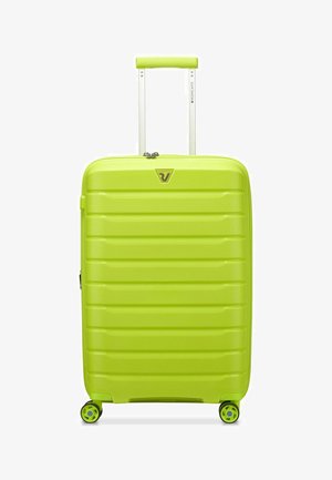 Valise rigide d'un vert lime éclatant avec une texture striée, poignée rétractable et quatre roulettes. Présente un logo sur l'avant.
