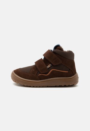 Baskets montantes marron pour enfants avec double bride velcro, tissu texturé, empiècements en suède et semelle en caoutchouc sur fond blanc.