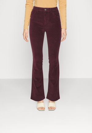 Burgundy corduroy flared pants with a high waist, front pockets, and a single button closure. Features a soft texture and slight sheen.