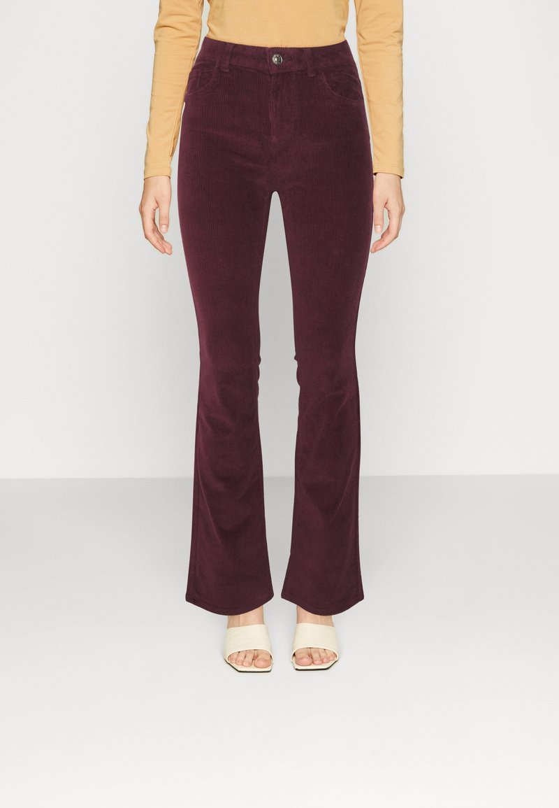 Burgundy corduroy flared pants with a high waist, front pockets, and a single button closure. Features a soft texture and slight sheen.