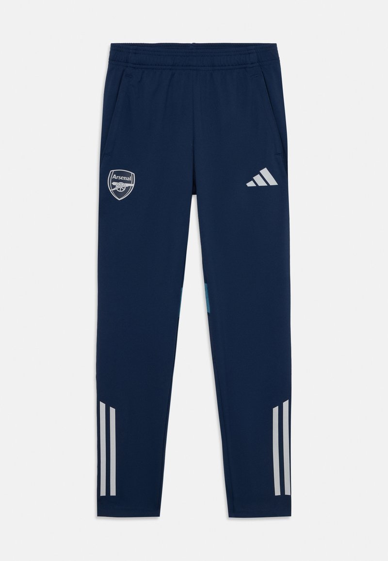 Tamsiai mėlynos sportinės kelnės su Arsenal logo, elastingu juosmeniu, dviem šoninėmis kišenėmis ir pilkais trimis dryžiais apatinėje kelnių dalyje.