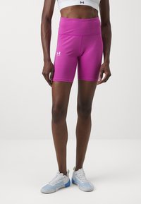 Růžové sportovní kraťasy s vysokým pasem a bílým logem, doplněné strukturovanými bílými a modrými sportovními botami.