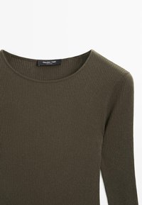 Zielono-oliwkowy, prążkowany top z długim rękawem z okrągłym dekoltem i miękką strukturą. Metka z napisem "Massimo Dutti." Zbliżenie na tkaninę.
