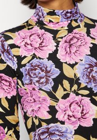 Schwarzfarbener Rollkragenpullover mit floralem Muster aus rosa und blauen Rosen, akzentuiert mit grünen Blättern, aus weichem, dehnbarem Stoff.