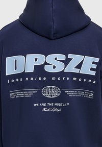 Sweat à capuche bleu marine avec un grand texte "DPSZE" en bleu clair, des phrases motivantes blanches plus petites, et un logo de globe avec le slogan "NOUS SOMMES LA DYNAMIQUE".