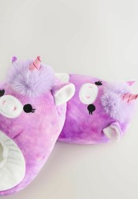 Chaussons en peluche violets en forme de licorne, avec une texture douce, présentant une corne rose, des oreilles blanches et des détails faciaux brodés.