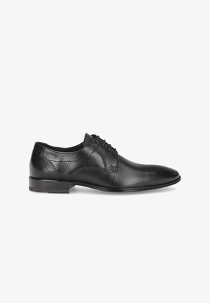 Chaussure habillée en cuir noir avec un design élégant à bout pointu, présentant une texture lisse et des détails de couture subtils, un laçage, et un talon bas.