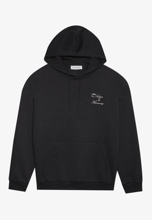 Black hoodie with a kangaroo pocket, drawstring hood, and embroidered text, "Nature In Harmony," featuring subtle motifs. Soft fabric texture.