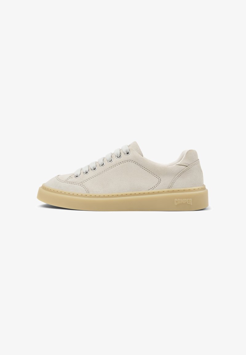 Baskets basses en suède beige avec lacets blancs et semelle épaisse en caoutchouc marron clair, logo Camper embossé sur le côté du talon.