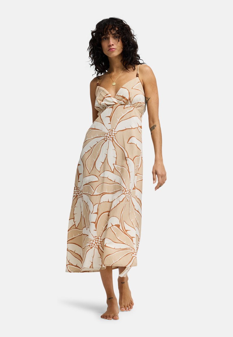 Robe beige légère avec motif floral marron, encolure en V et fines bretelles. Longueur jusqu'au sol. Texture lisse, coupe décontractée.