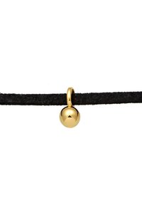 Colgante esférico de oro unido a un cordón negro. El colgante presenta un acabado reflectante con una textura suave, y el cordón parece suave y mate.