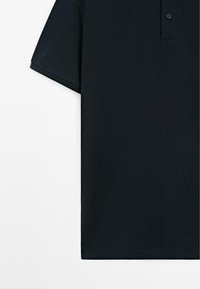 Mørkeblå polo-shirt med ribbet tekstur, korte ærmer, tre-knaps lukning og sideslids ved kanten.