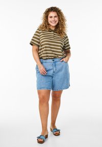 Polo shirt rayé olive et crème, shorts en denim et sandales bleues à enfiler. Caractéristiques : coupe décontractée et shorts à revers.