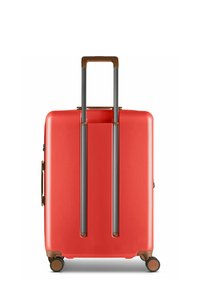 Maleta de duro en un vibrante color rojo, con un diseño elegante, dos asas telescópicas grises y cuatro ruedas giratorias; superficie de textura suave.