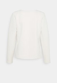 Weißer Pullover mit langen Ärmeln und strukturiertem Muster, mit Zickzack-Details an den Seiten und einem runden Ausschnitt.