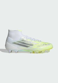 Ποδοσφαιρικό παπούτσι σε λευκό και νέον κίτρινο με εφαρμογή ψηλής κάλτσας αστραγάλου, κορδόνια και διαφανή σόλα με καρφιά για παιχνίδι σε σκληρό έδαφος.