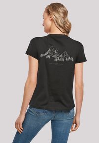 Zwarte t-shirt met een witte grafiek van een berg en een boom op de achterkant. Korte mouwen met een relaxte pasvorm. Zacht, lichtgewicht katoenmateriaal.