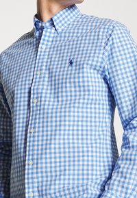 Blå och vit rutmönstrad knapp-up skjorta med klassisk krage, broderad logotyp och pärlknappar i en mjuk bomullstyg.