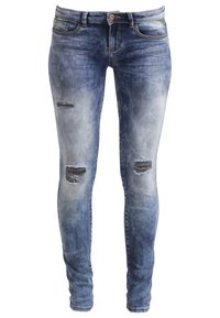 Jeans ajustados de denim, con un lavado azul claro desvanecido, dos áreas desgastadas en la parte frontal, cinco bolsillos y cierre de botón.
