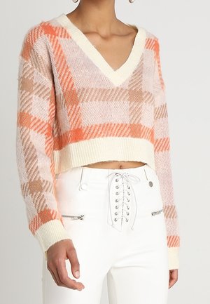 Pull en crochet, court, dans des couleurs pastel avec des motifs à carreaux orange et beige, présentant un décolleté en V et des poignets côtelés.