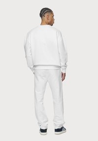 Pegador LOGO WIDE PANTS - Pantalones deportivos - white