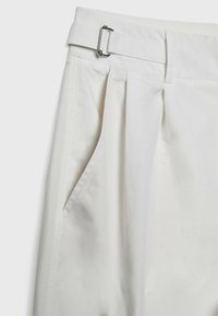 Pantalon blanc taille haute avec plis latéraux, poche en biais et ceinture en tissu maintenue par une boucle rectangulaire argentée.