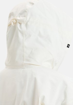 Biała kurtka przeciwdeszczowa z kapturem, o gładkiej fakturze, z bocznym sznurkiem do regulacji oraz małą czarną metką na plecach.