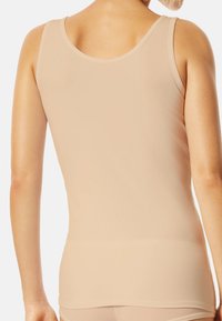 Débardeur beige clair en tissu lisse et extensible, avec un col arrondi et une coupe sans manches, offrant une silhouette ajustée.