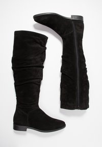 Schwarze Wildleder-Stiefel über das Knie mit einem lässigen Design, runder Zehenpartie und einem schwarzen Reißverschluss an der Innenseite. Flacher Absatz für Stabilität.