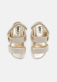 Metalliska guldöppna sandaler med vadderade remmar och justerbara kardborrestängningar, märkt med MM6 Maison Margiela inuti.